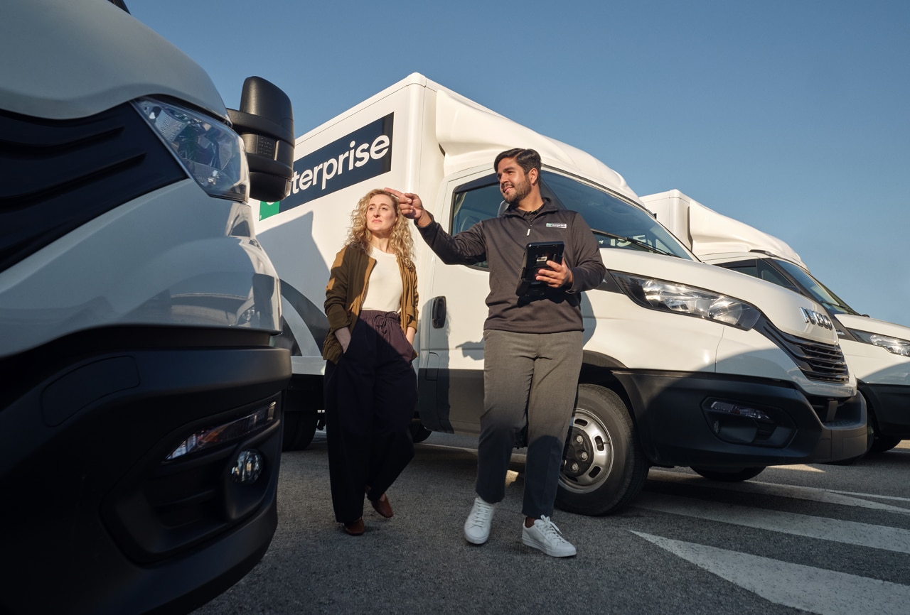 Man point at car in the parking lot while walking with a woman.