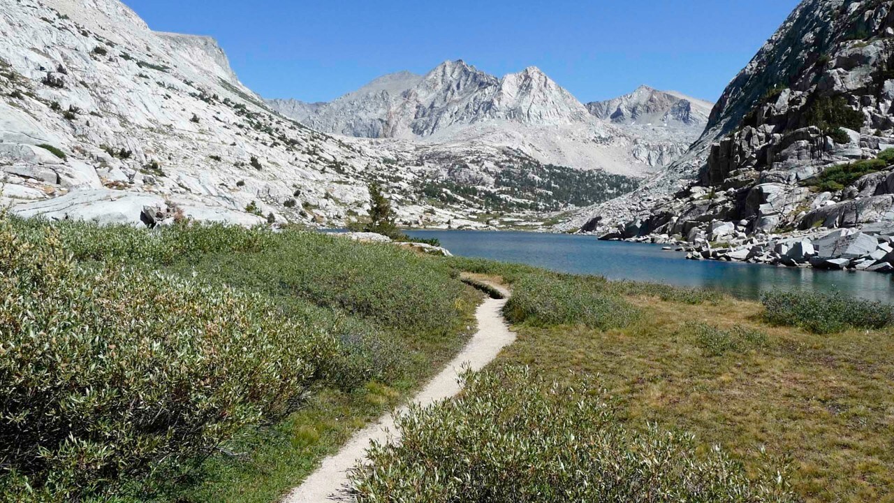 Hiking, backpacking trail  in the mountains leading to a glacial lake.