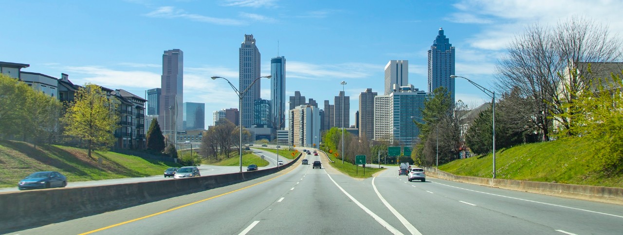 A view from the highway 10 as it approaches downtown Atlanta, Georgia. This image was shot from the road surface, giving the same perspective a driver would get as they enter the city. The skyline crosses most of the composition.